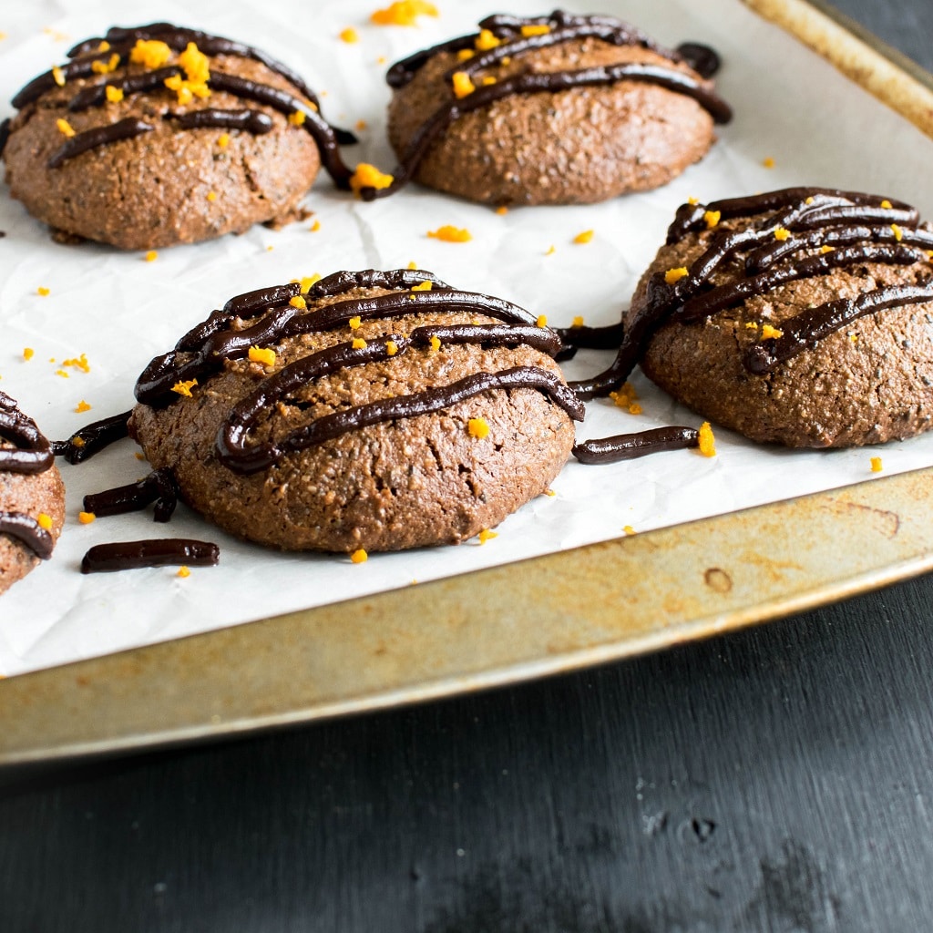 Chocolate Orange Ganache Protein Cookies with drizzled ganache is shown on the cookie sheet just after baking | kiipfit.com