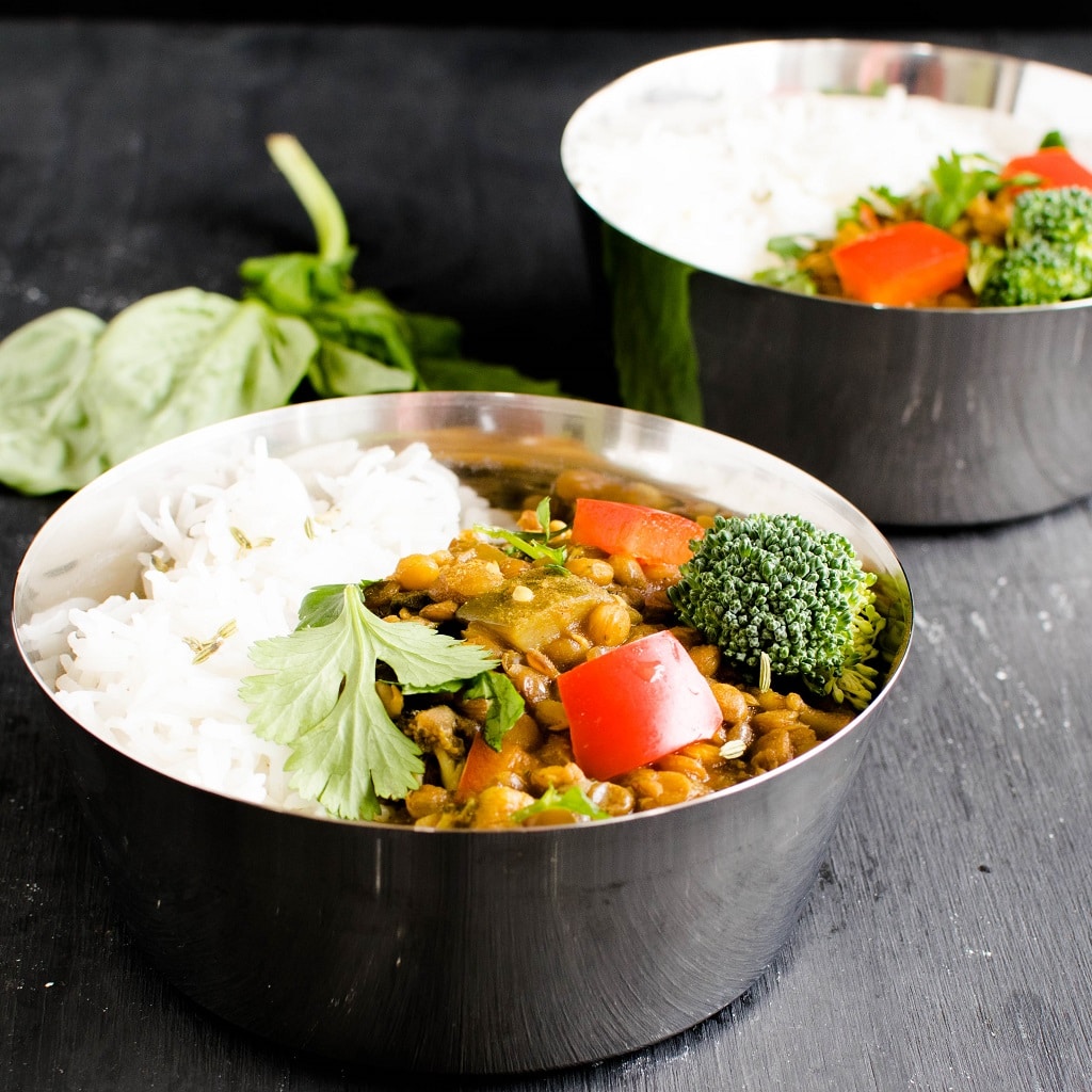 Two bowls full of Instant Pot Herbed Masala Lentil Curry along with steamed rice is shown in this image | kiipfit.com