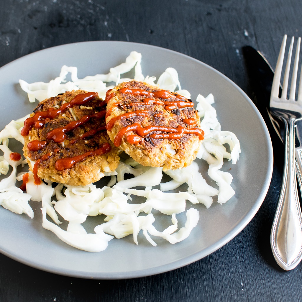 Thai Peanut Chickpea Patties are shown on a bed of side salad with cutlery as the prop | kiipfit.com