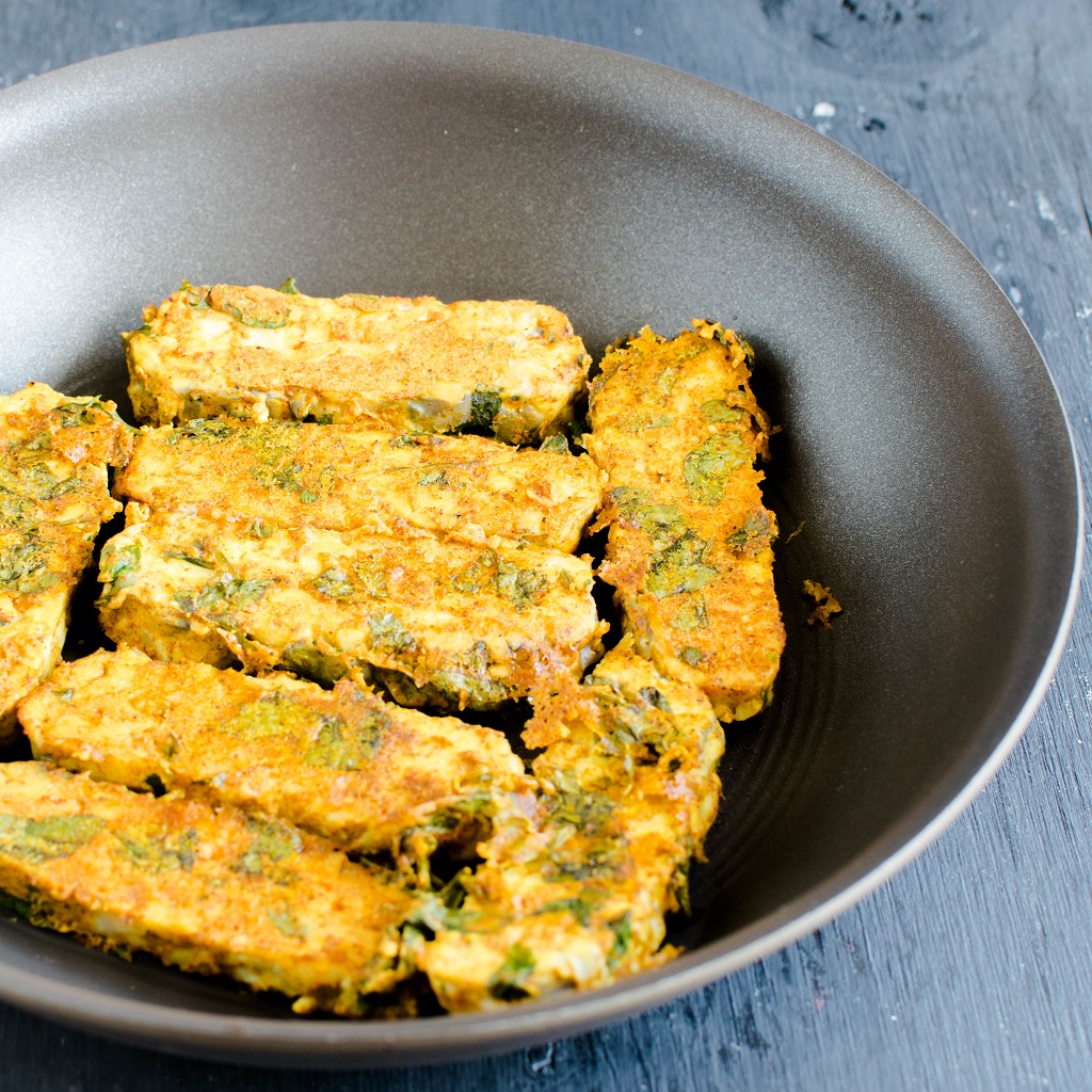 Cooked tempeh in a pan is shown in this image.